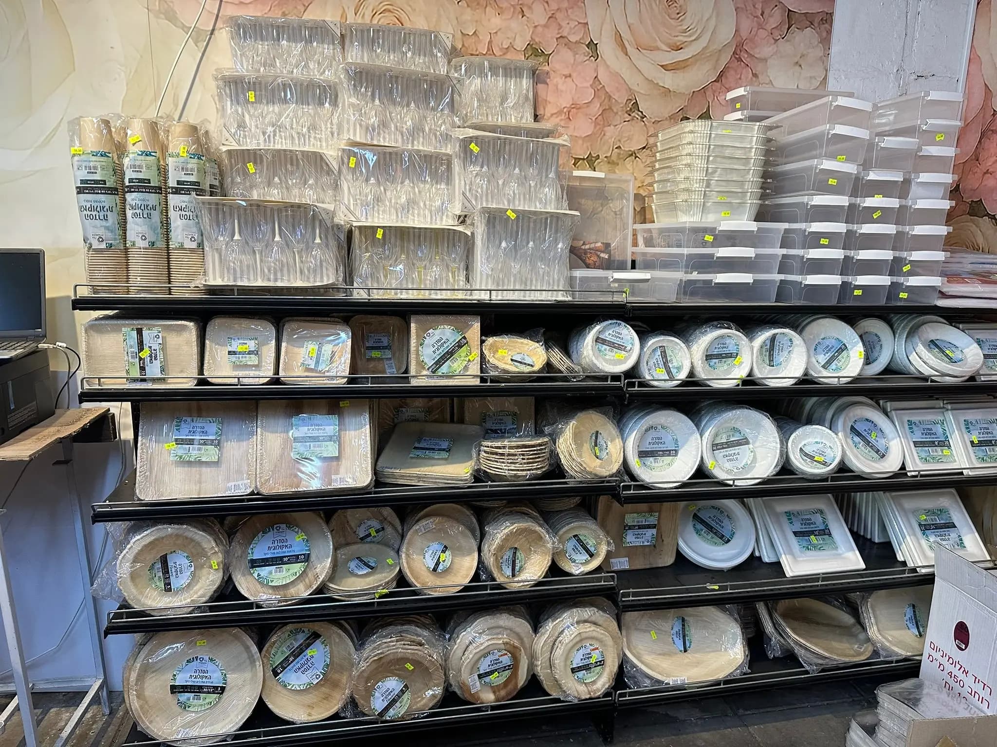 מדפים עם מכלים ומגשים חד פעמיים שקופים וחומים ערוכים לפי גודל